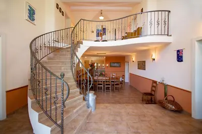 a spiral staircase in a house with a dining room at Villa Anton - The Old Dairy in Hrušica