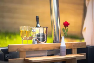 a table with a bottle of champagne and two glasses at Alp Glamping Village in Radovljica