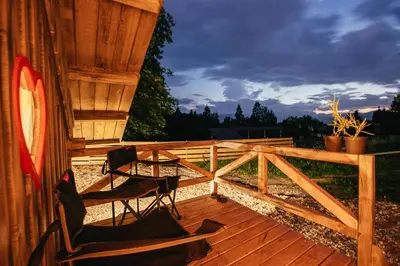 two chairs and a table on a wooden deck at Alp Glamping Village in Radovljica