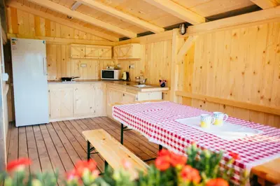a kitchen with a table with a red and white checkered table cloth at Alp Glamping Village in Radovljica