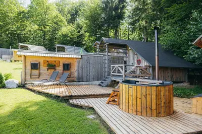 a log cabin with a deck and a house at Alp Glamping Village in Radovljica