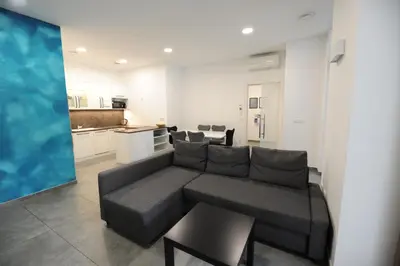 a living room with a couch and a kitchen at Argo Apartments in Ljubljana