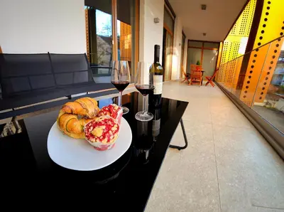 a plate of pastries and a glass of wine on a table at Argo Apartments in Ljubljana
