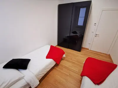 a bedroom with two beds with red and white at Argo Apartments in Ljubljana
