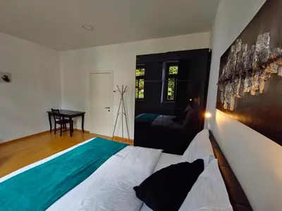 a bedroom with a bed and a table in it at Argo Apartments in Ljubljana