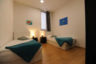 two beds sitting in a room with a window at Argo Apartments in Ljubljana