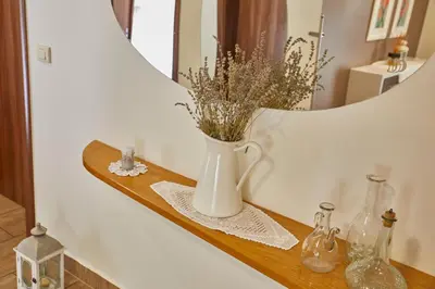 a vase with flowers on a shelf in front of a mirror at Hostel Delalut in Ravne na Koroškem