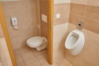 a bathroom with a toilet and a urinal at Hostel Delalut in Ravne na Koroškem