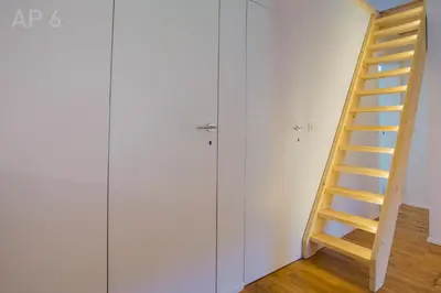 a wooden staircase in a room with a white wall at Apartments Perla in Zgornje Gorje