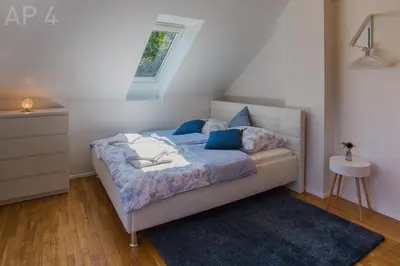 a bedroom with a bed with blue sheets and a window at Apartments Perla in Zgornje Gorje