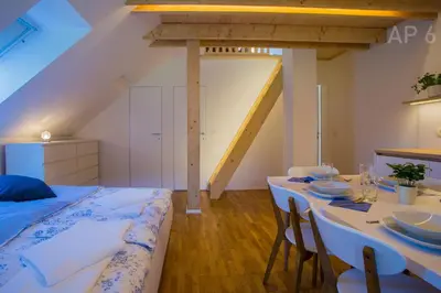 a bedroom with a bed and a table with chairs at Apartments Perla in Zgornje Gorje