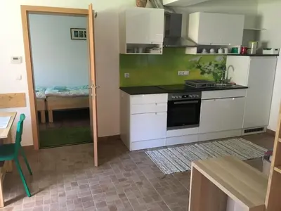 a kitchen with white cabinets and a stove top oven at Apartma Tajč in Bohinj