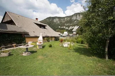 a backyard of a house with a grass yard at Apartma Tajč in Bohinj