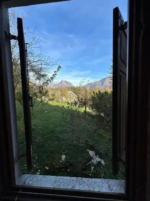 an open window with a view of a field at Holiday house Pr Robč in Bovec