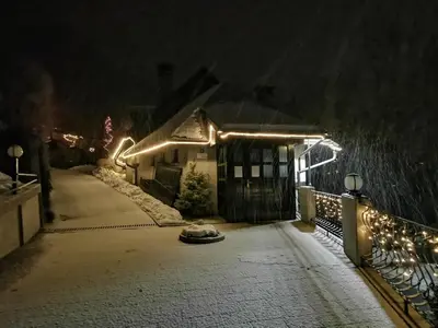 a house with lights on the side of it at night at Apartmaji Mak in Jesenice