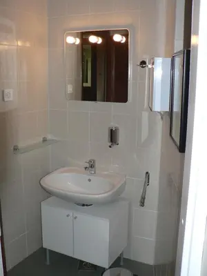 a white bathroom with a sink and a mirror at Apartmaji Mak in Jesenice
