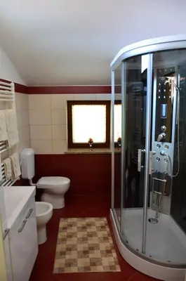 a bathroom with two toilets and a glass shower at Apartma Louis in Dutovlje