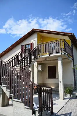 a small house with a balcony and a staircase at Apartma Louis in Dutovlje
