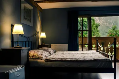 a blue bedroom with a bed and a window at pr' Drašlerju in Dovje