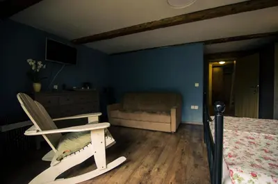a bedroom with a bed and a chair and a couch at pr' Drašlerju in Dovje