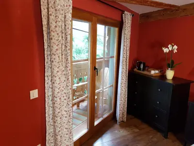 an orange room with a window and a dresser and a door at pr' Drašlerju in Dovje