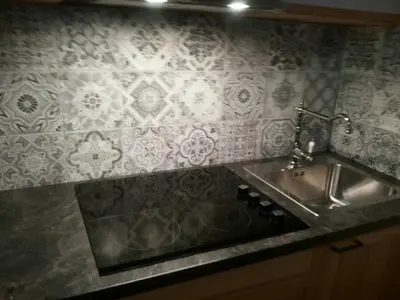 a kitchen with a sink and a tile wall at Apartments Otašević in Kranjska Gora