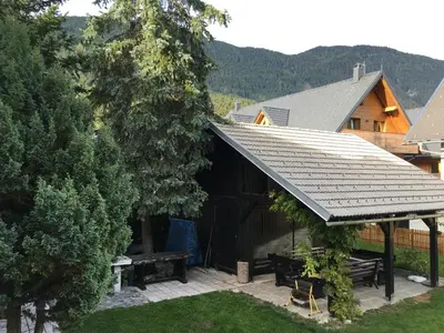 a cabin with a picnic table and a roof at Apartments Otašević in Kranjska Gora