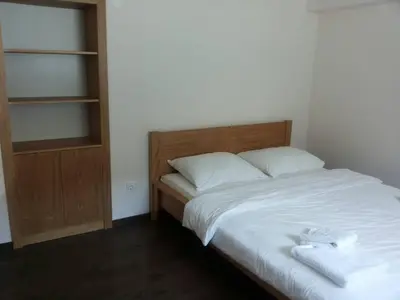 a bed with white sheets and a wooden headboard at Apartments Otašević in Kranjska Gora