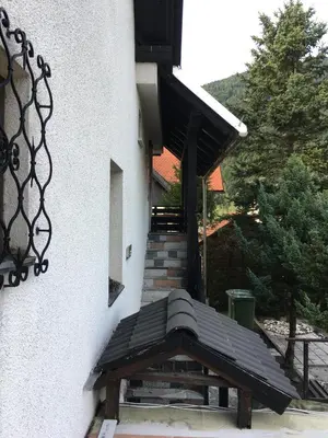a wooden bench sitting outside of a building with stairs at Apartments Otašević in Kranjska Gora