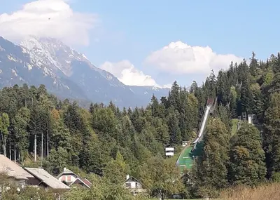 a house in a forest with mountains in the background at Apartmaji Mojca in Križe