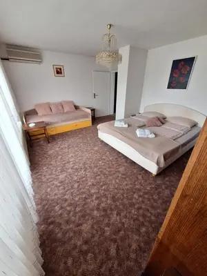 a bedroom with two beds and a chandelier at Apartmaji Mojca in Križe