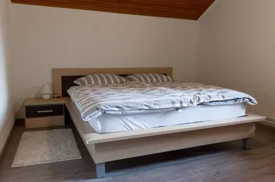 a bedroom with a bed and a night stand at Hanzi Holiday Home in Rečica ob Savinji