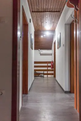 a hallway leading to a room with white walls and wood ceilings at Hanzi Holiday Home in Rečica ob Savinji