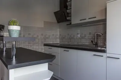 a kitchen with white cabinets and a sink at Hanzi Holiday Home in Rečica ob Savinji