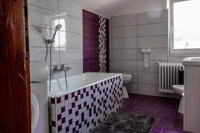a bathroom with a tub and a toilet and a sink at Hanzi Holiday Home in Rečica ob Savinji