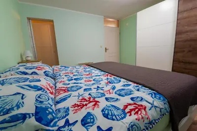 a bedroom with a bed with a blue and white comforter at Bled Honey Bee Apartment in Bled