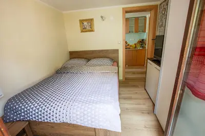 a small bedroom with a bed and a kitchen at Bled Honey Bee Apartment in Bled
