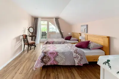 a bedroom with two beds and a chair at Apartma Summer Garden in Bled