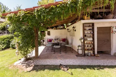 a patio with a table and chairs under a tree at Apartma Summer Garden in Bled