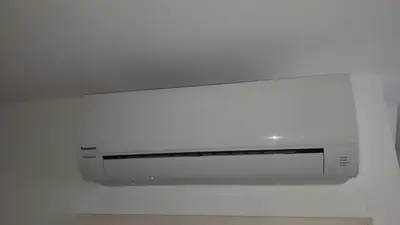 a white microwave hanging on a white wall at Tabor - Apartments Rozmanova Street in Ljubljana