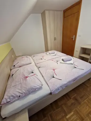 a bed with pink sheets and pillows on it at Apartment Ravnik Brod 13 in Bohinj