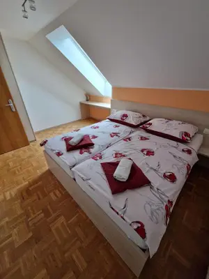 a bedroom with a bed with red and white blankets and pillows at Apartment Ravnik Brod 13 in Bohinj