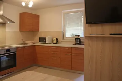 a kitchen with wooden cabinets and a microwave at Apartment Ravnik Brod 13 in Bohinj