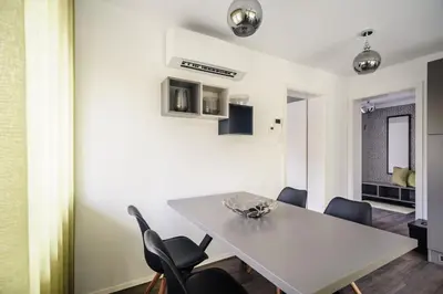 a dining room with a white table and chairs at Apartments Villa Tatiana in Bled