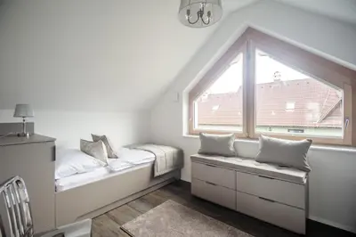 a white room with a window and two beds at Apartments Villa Tatiana in Bled
