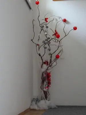 a vase with a tree with red berries in it at Apartment Tjaša in Radovljica