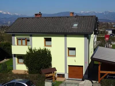 a white house with a brown roof at Apartment Tjaša in Radovljica