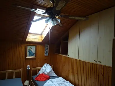 a room with a ceiling fan and a bed at Apartment Tjaša in Radovljica