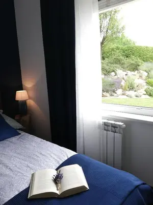 a bedroom with a bed with a book and a window at MAPLE place in Pivka
