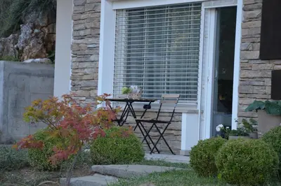 a table and chairs on the porch of a house at MAPLE place in Pivka
